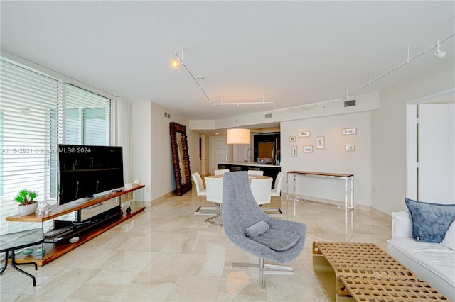 living room with light tile floors, track lighting, and sink