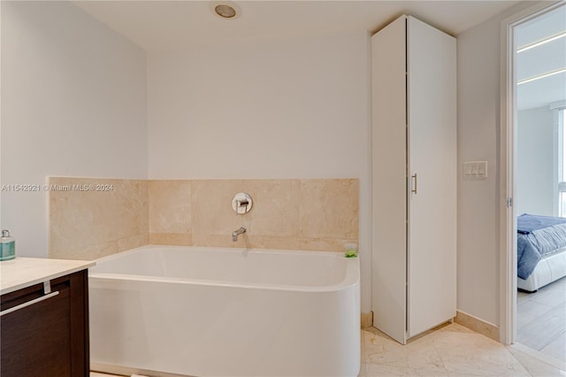 bathroom with a bath, vanity, and tile floors