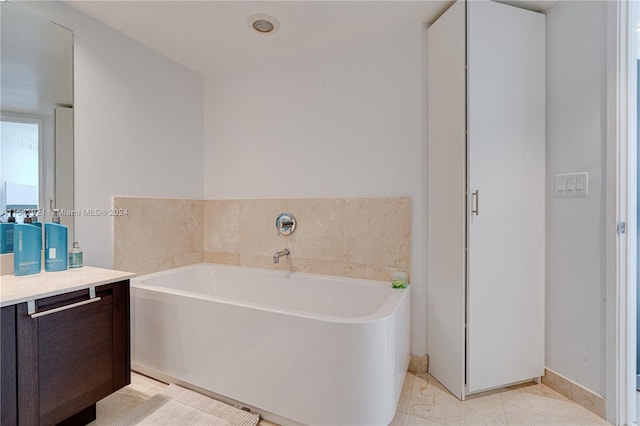 bathroom with tile floors, vanity, and a bath to relax in