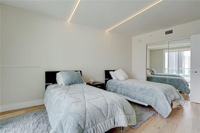 bedroom with light hardwood / wood-style floors and a closet