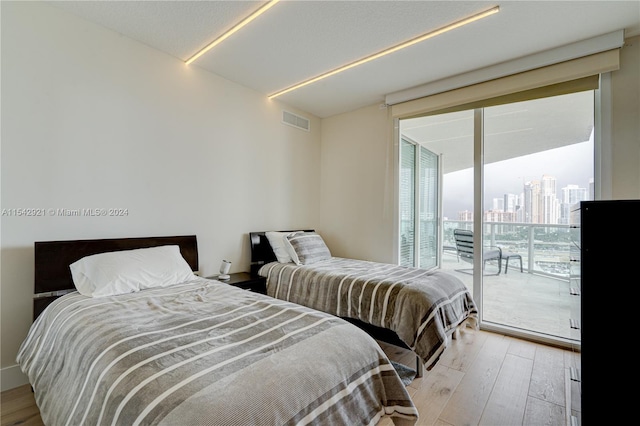 bedroom with access to outside and light wood-type flooring