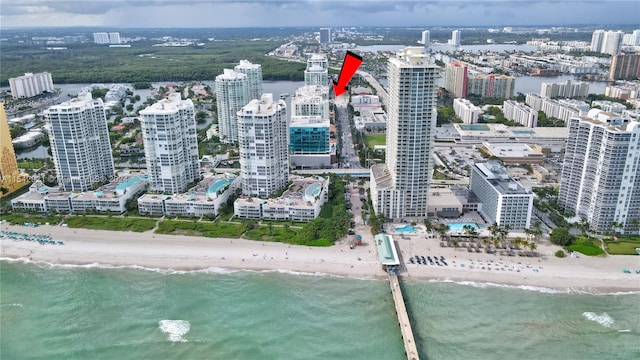 birds eye view of property with a water view and a beach view