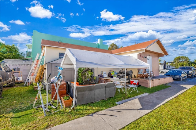 view of home's exterior with outdoor lounge area, a shed, and a yard