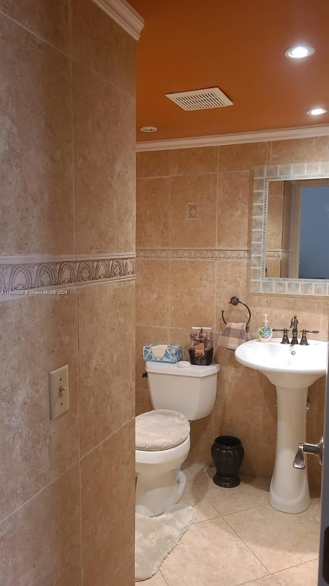 bathroom with tile flooring, tasteful backsplash, toilet, and tile walls