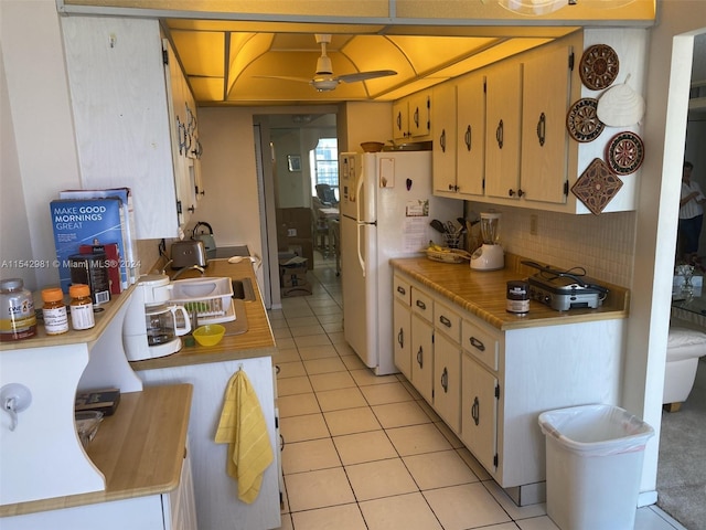 kitchen with backsplash, white fridge, ceiling fan, and light tile patterned flooring