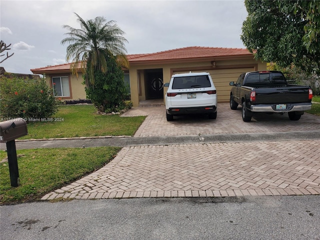 ranch-style home with a front yard and a garage