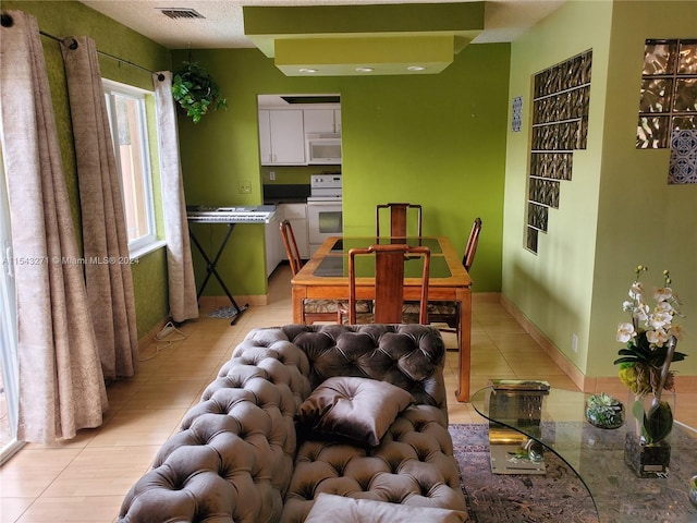 tiled dining area with a textured ceiling