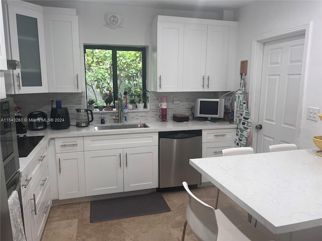 kitchen featuring backsplash, white cabinets, light tile floors, and dishwasher