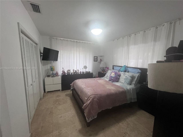 tiled bedroom featuring a closet