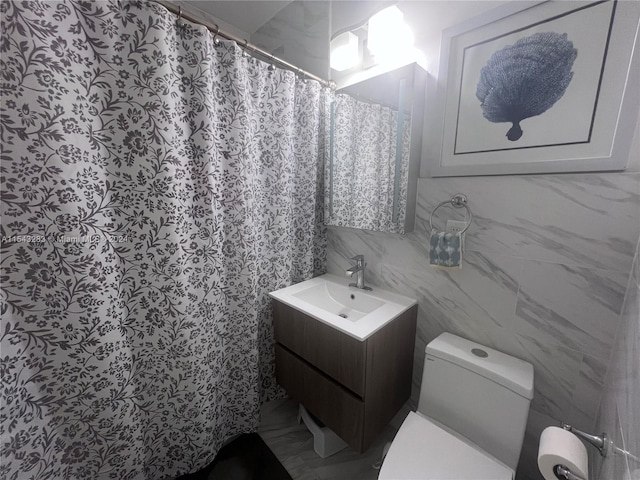 bathroom featuring tile walls, toilet, and vanity