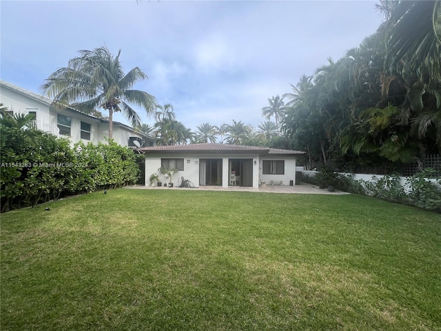 rear view of property featuring a yard