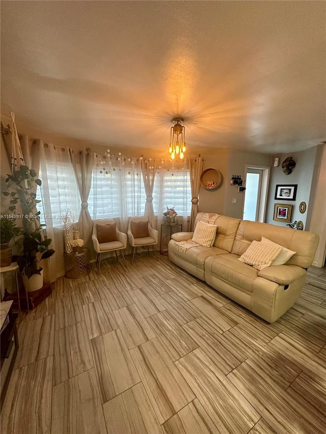 unfurnished living room featuring a textured ceiling and an inviting chandelier