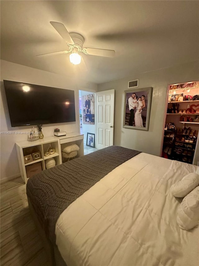 bedroom featuring a walk in closet, a closet, visible vents, and ceiling fan