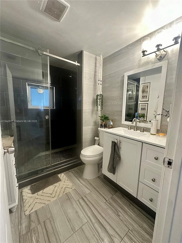 full bath featuring toilet, a shower stall, visible vents, and vanity