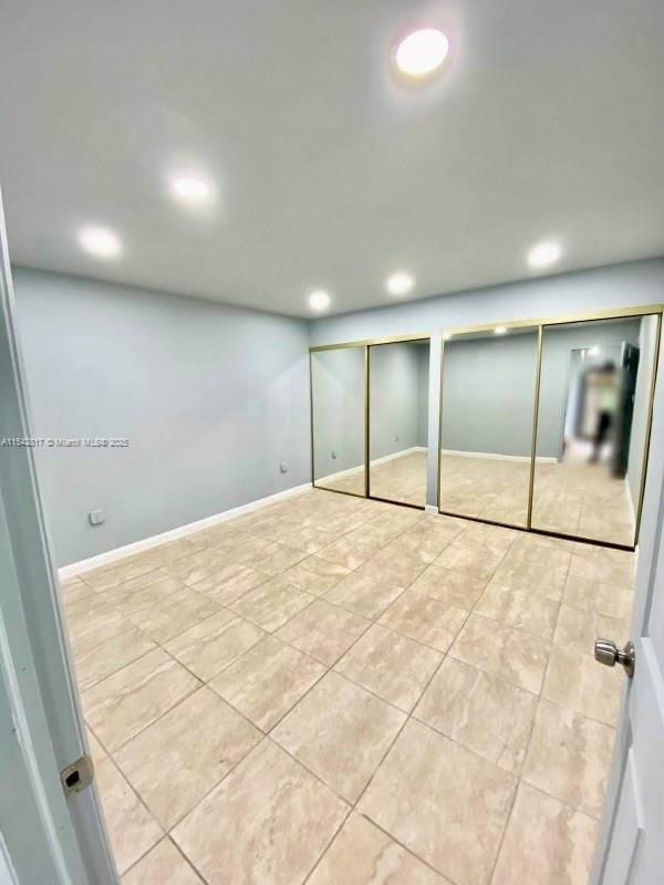 below grade area with recessed lighting, light tile patterned flooring, and baseboards