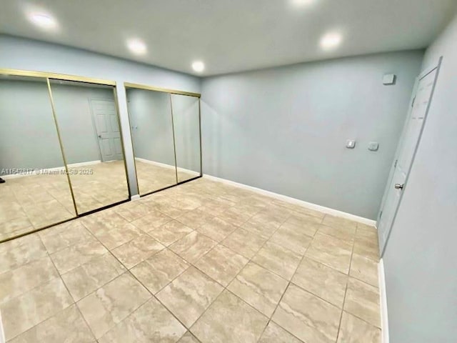 unfurnished bedroom featuring baseboards, multiple closets, and recessed lighting