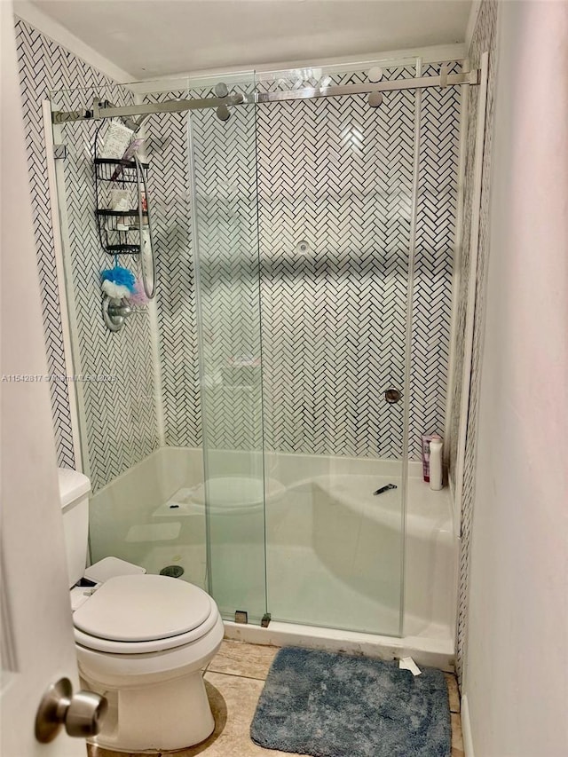 full bathroom with tile patterned flooring, a shower stall, and toilet