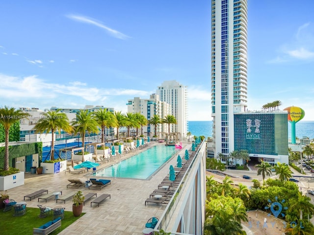 view of pool featuring a patio area and a water view