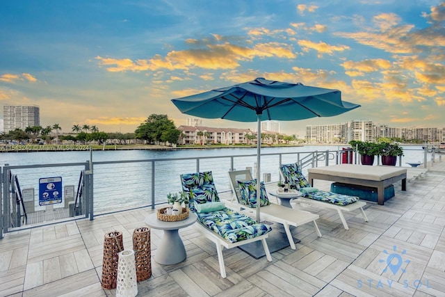 patio terrace at dusk with a balcony and a water view