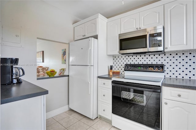 kitchen featuring white appliances, decorative backsplash, light tile patterned floors, and white cabinets