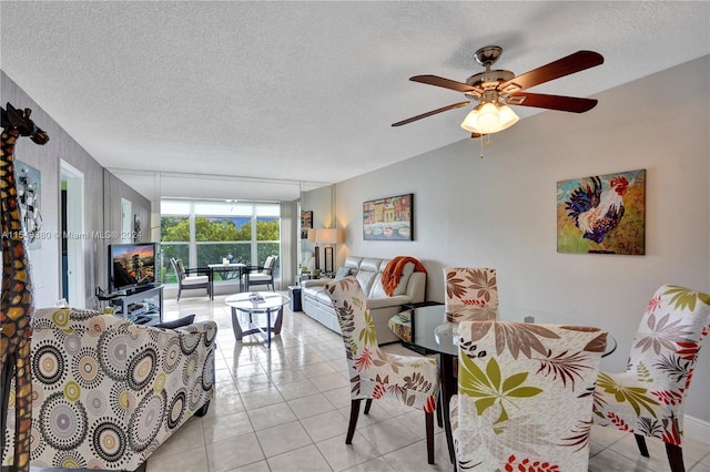 living room with a textured ceiling, ceiling fan, and light tile patterned floors