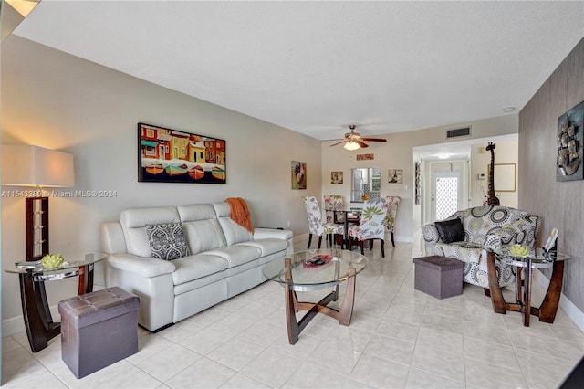 tiled living room with a textured ceiling and ceiling fan