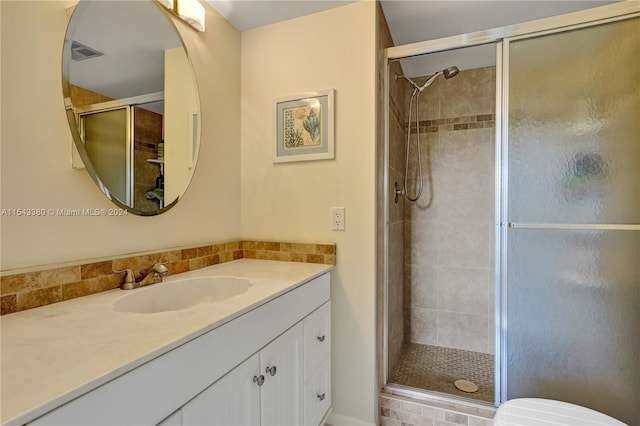 bathroom with vanity, toilet, and an enclosed shower