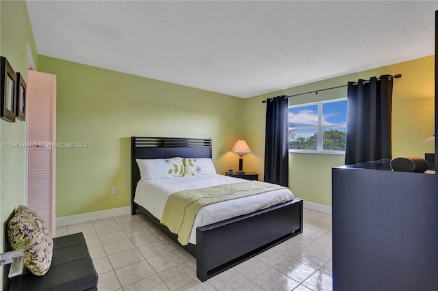 bedroom with a textured ceiling and light tile patterned floors