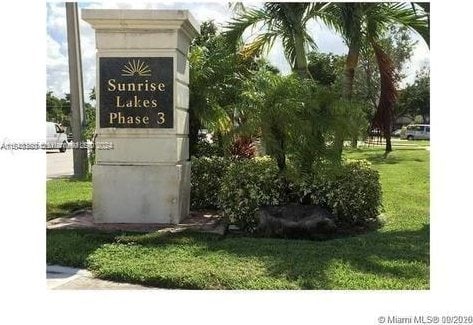 community / neighborhood sign featuring a lawn