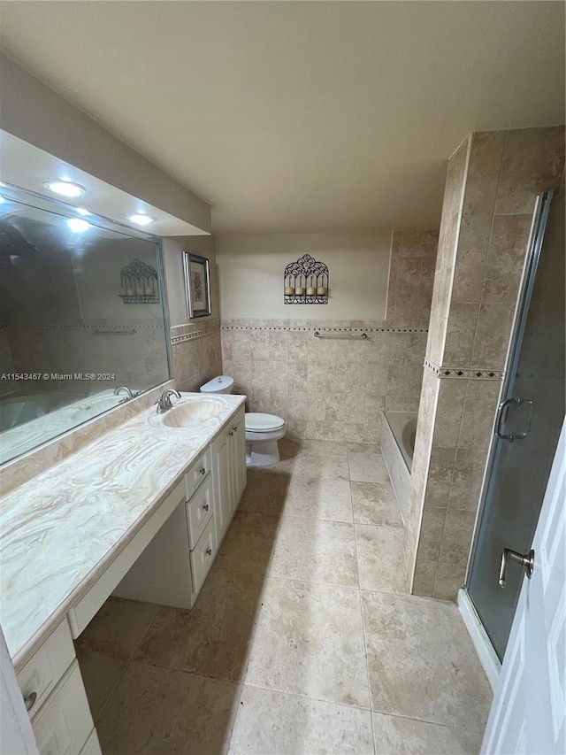 bathroom with vanity with extensive cabinet space, tile walls, a shower with shower door, tile flooring, and toilet