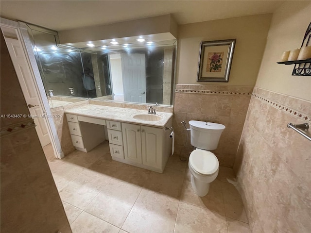 bathroom with vanity, toilet, tile flooring, and tile walls