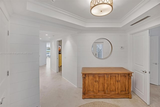 corridor featuring a raised ceiling and ornamental molding