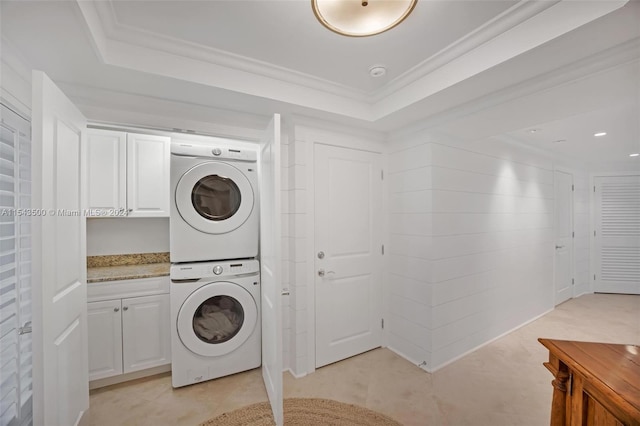 laundry area featuring light tile floors and stacked washer and dryer