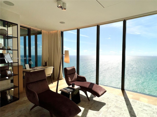 sunroom featuring a water view