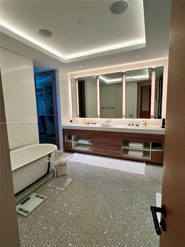 bathroom with a tray ceiling and dual bowl vanity