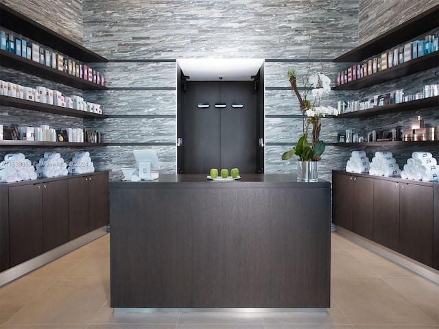 bar featuring light tile floors and dark brown cabinetry