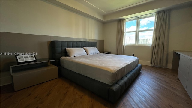 bedroom with dark wood-type flooring