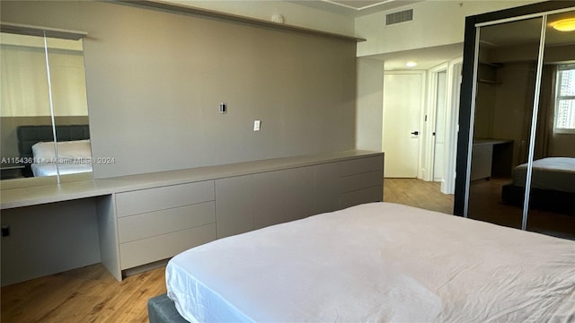 bedroom with light hardwood / wood-style floors and a closet