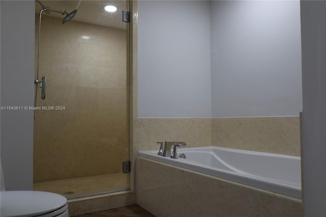 bathroom featuring shower with separate bathtub and toilet