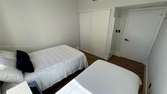 bedroom featuring a closet and dark wood-type flooring