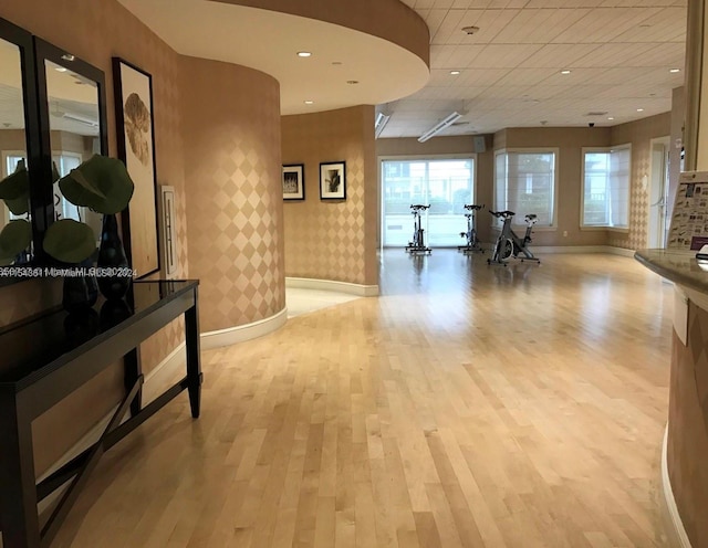 interior space with a paneled ceiling and light hardwood / wood-style floors