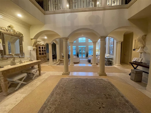 interior space featuring a towering ceiling and decorative columns