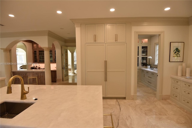 kitchen featuring ornamental molding, sink, and white cabinets