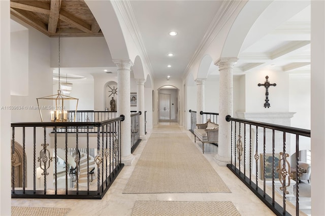 hallway with coffered ceiling, an inviting chandelier, and decorative columns