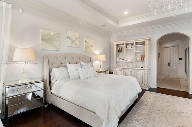 bedroom with ornamental molding, a raised ceiling, and dark hardwood / wood-style flooring