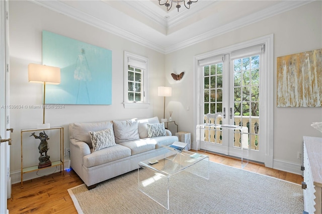 living room with a raised ceiling, ornamental molding, radiator, french doors, and light hardwood / wood-style floors