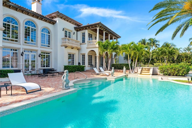 view of swimming pool with french doors and a patio