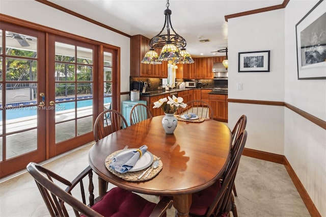 tiled dining space featuring sink, crown molding, a notable chandelier, and french doors