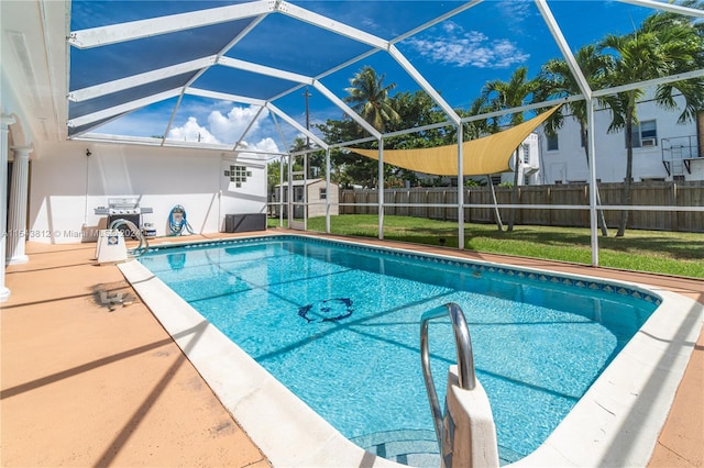 view of swimming pool with a lanai and a lawn