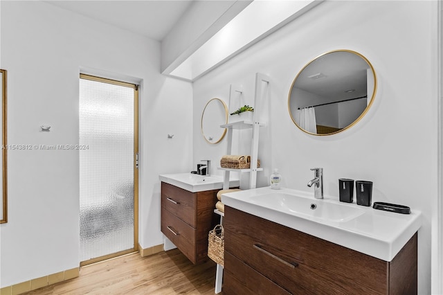 bathroom featuring hardwood / wood-style flooring and dual bowl vanity